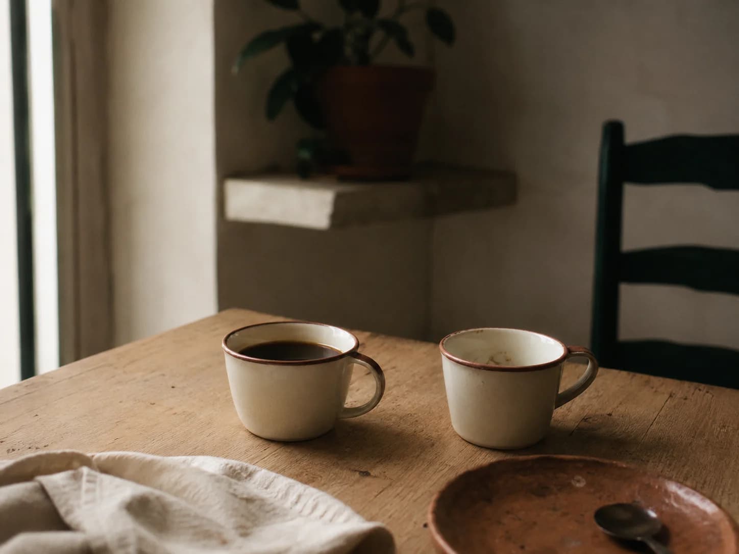 detalhe editorial de duas xícaras de café cerâmica numa mesa de madeira clara, sugestão de duas pessoas que sentaram juntas